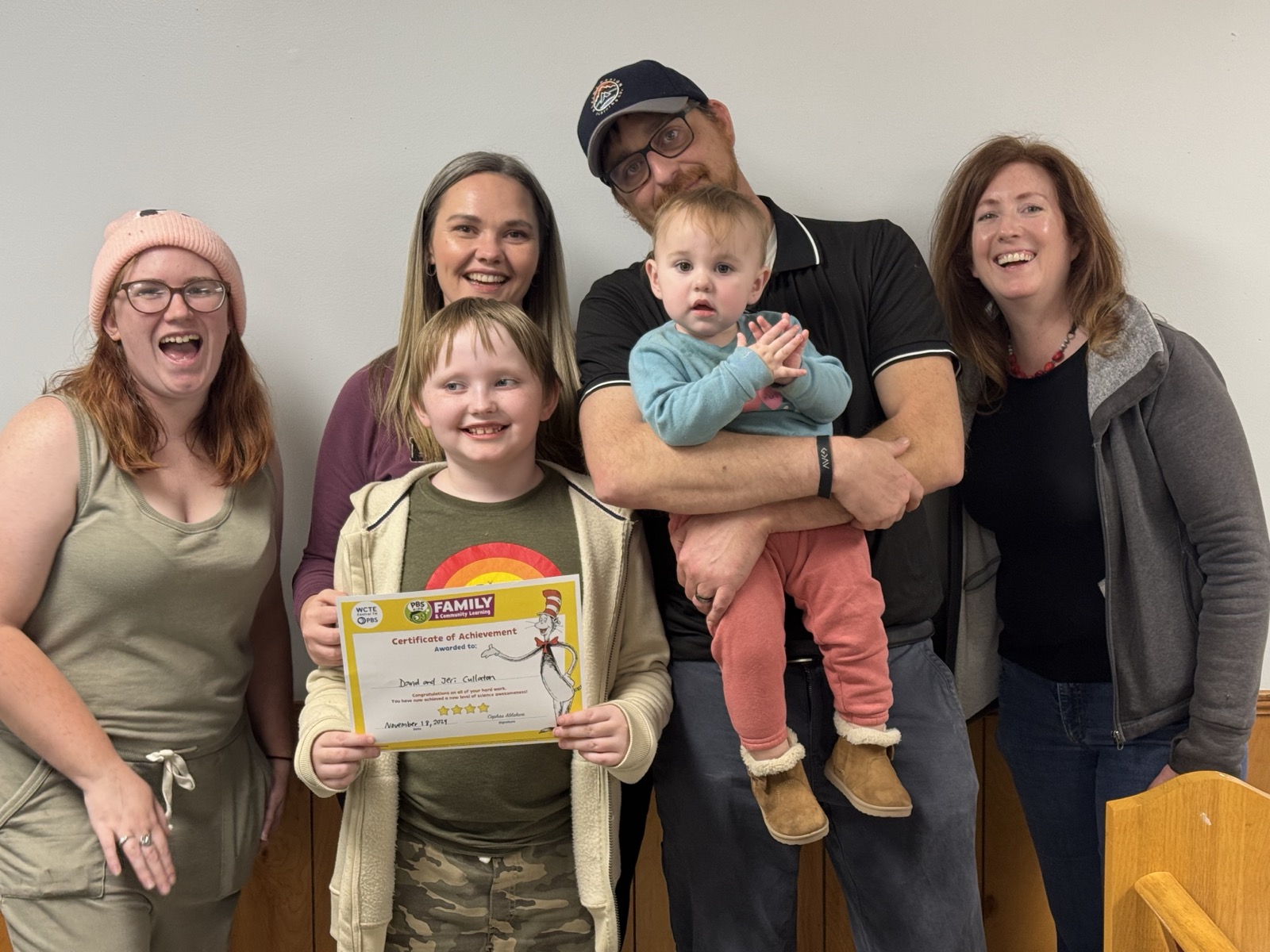 Family celebrating with Certificate of Achievement at program milestone